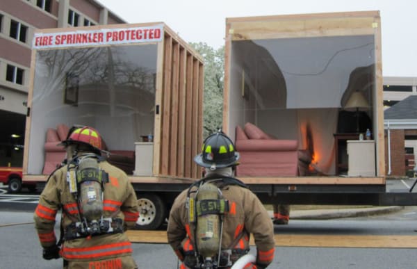 Firefighters conducting a home fire sprinkler demonstration