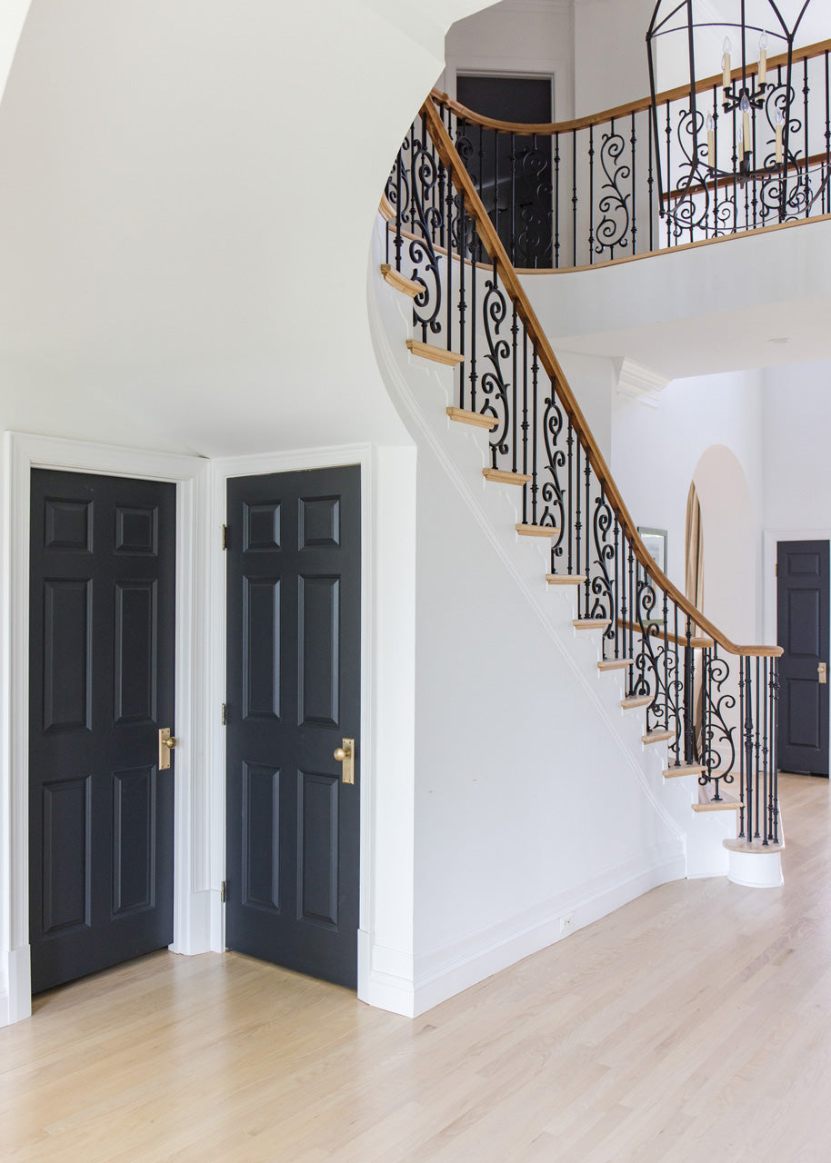 arched manor foyer black doors brass hardware